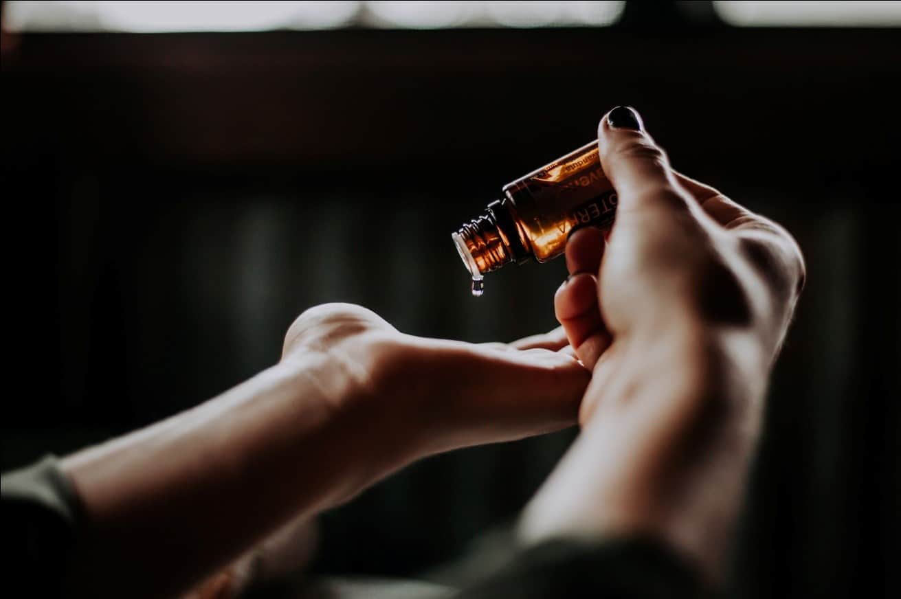 A person drops an aromatherapy CBD product onto their hand.