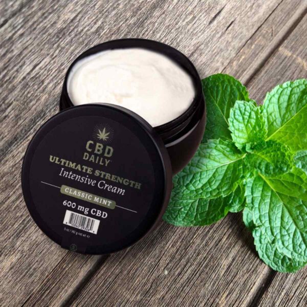 CBD Daily Intensive Cream Ultimate Strength Original Mint Jar Opened Up with Mint Leaf on the side High Resolution Image