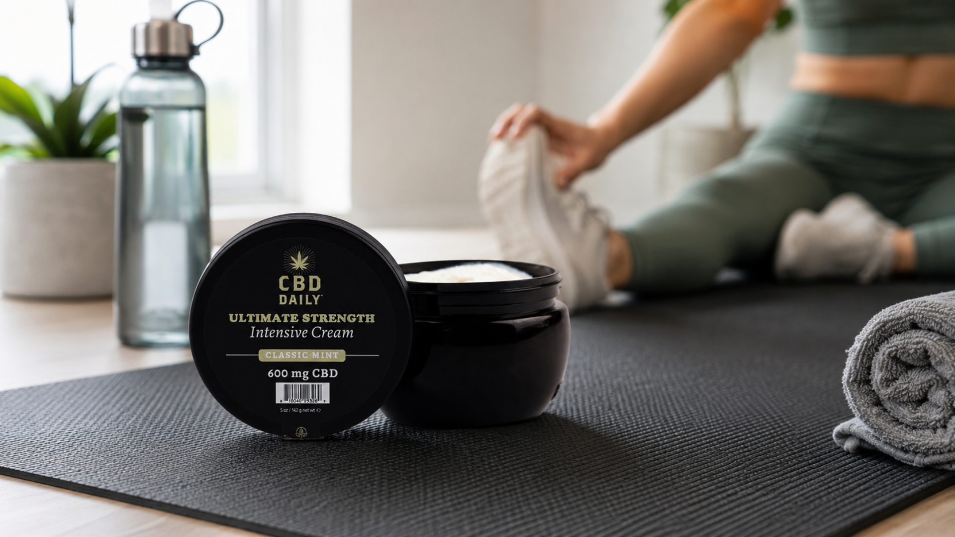 Person stretching beside CBD cream during an active recovery workout.
